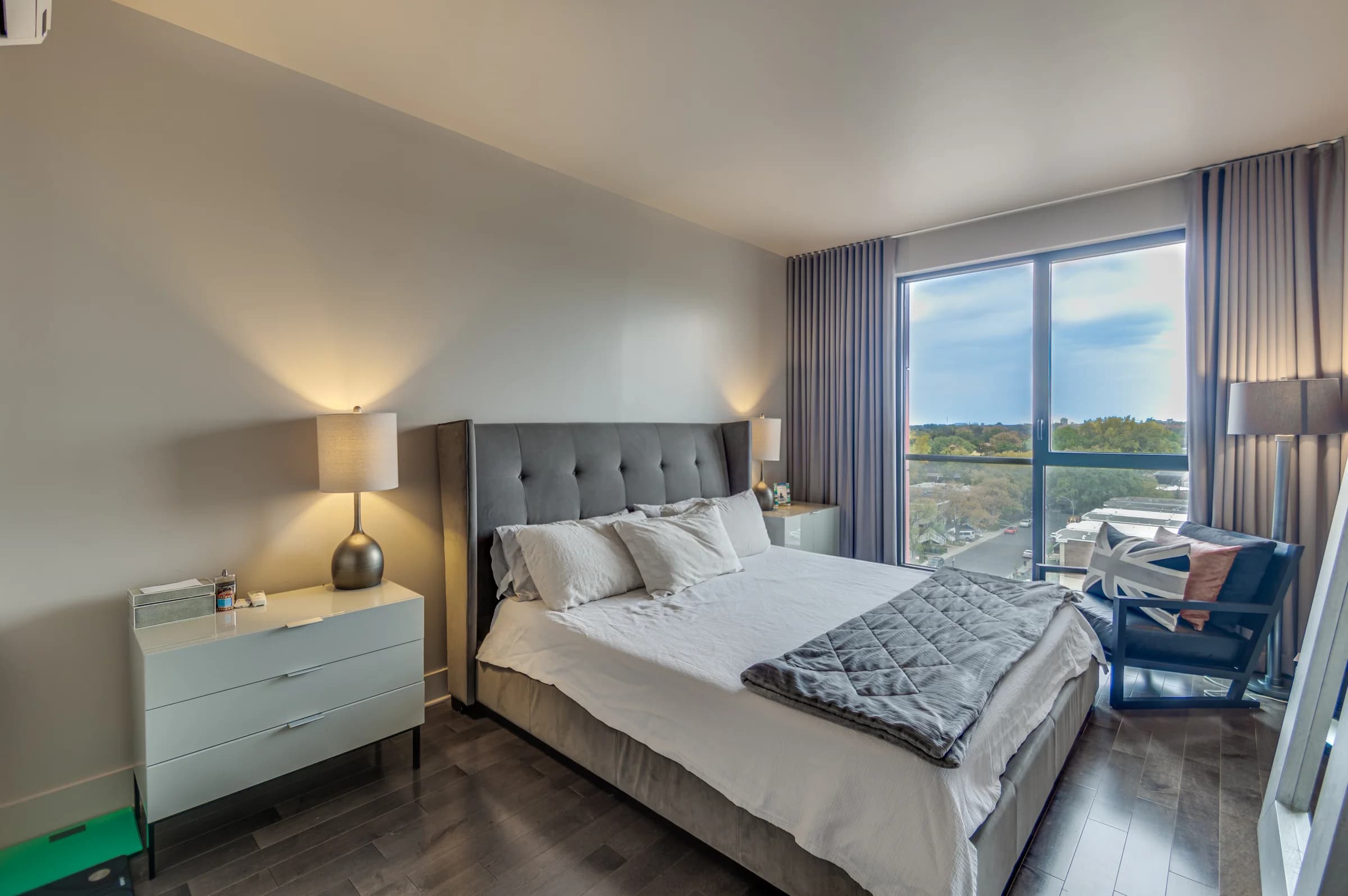 Chambre de condo avec tête de lit capitonnée et vue dégagée
