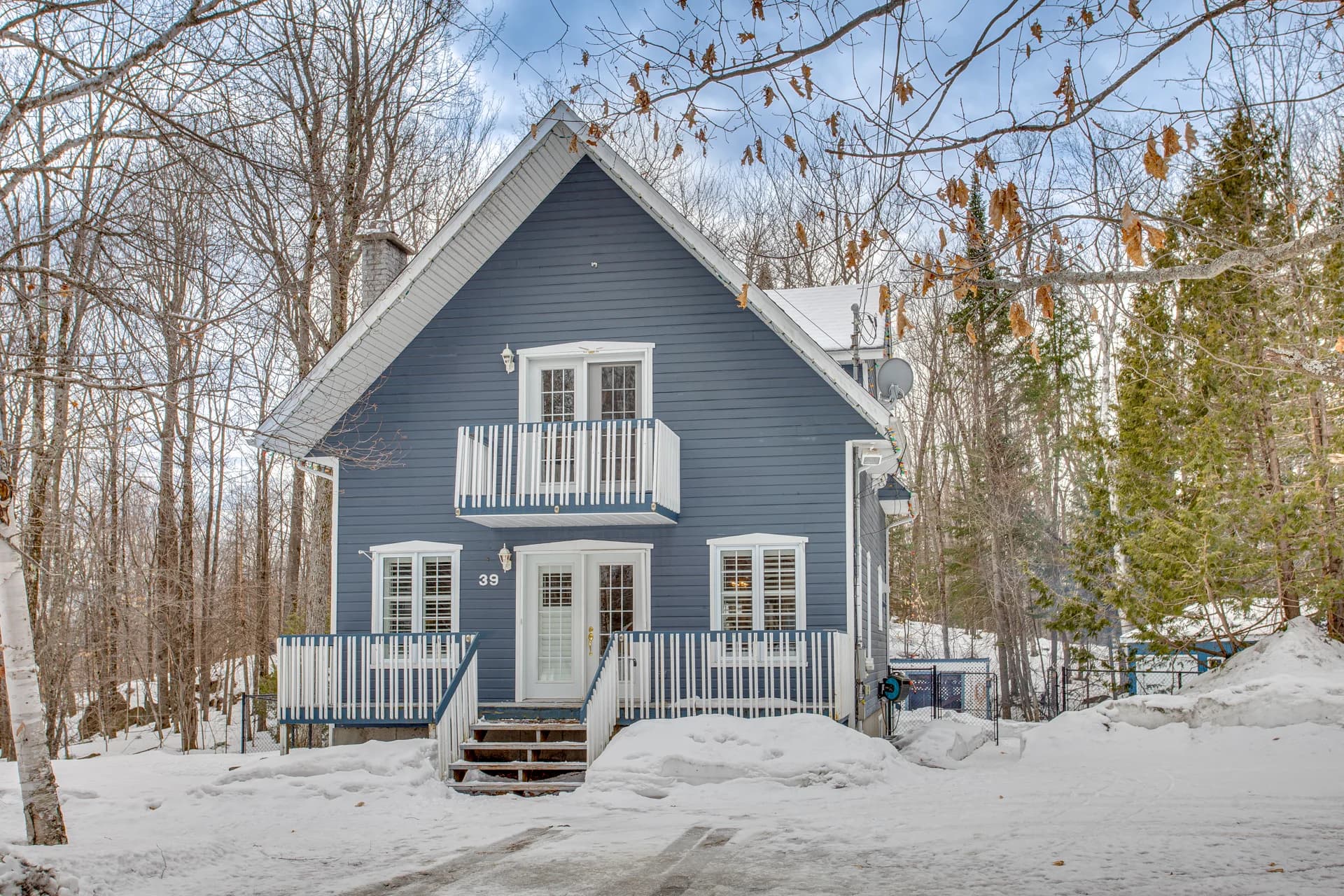 Maison bleue à toit pentu dans un décor hivernal