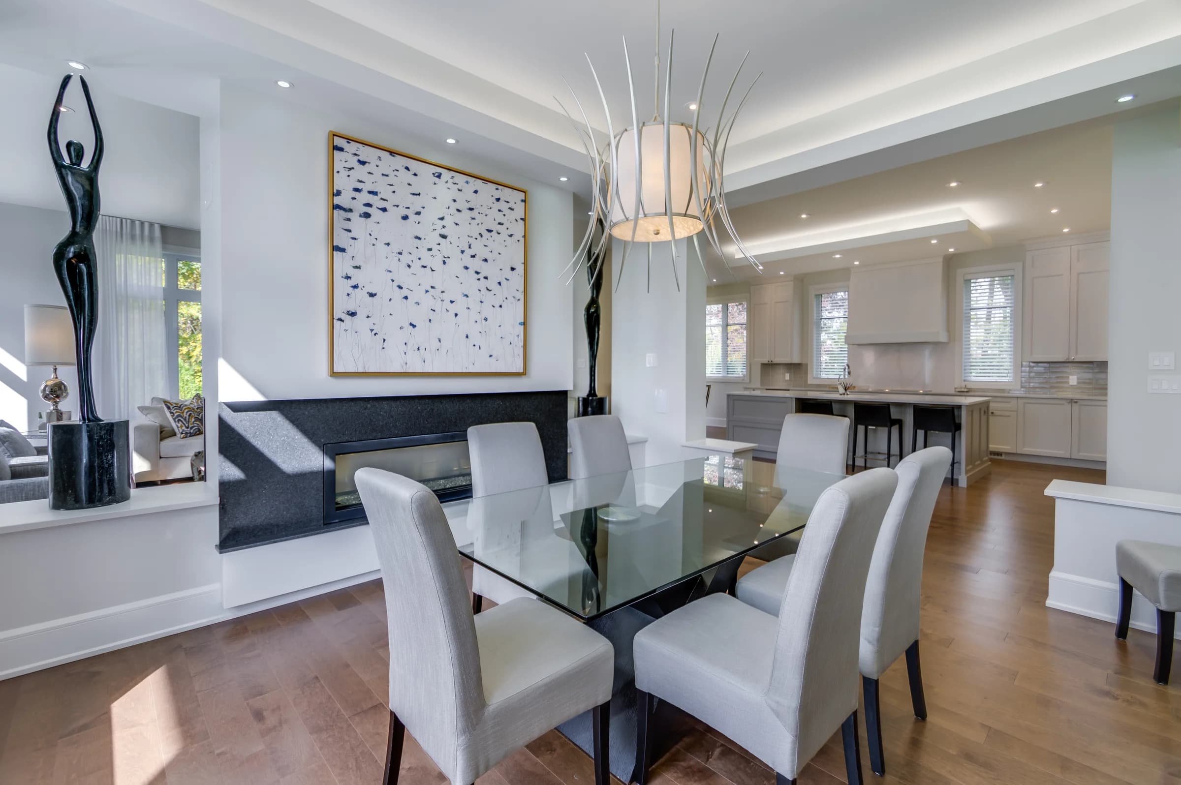 Salle à manger avec table en verre, chaises blanches et grand miroir