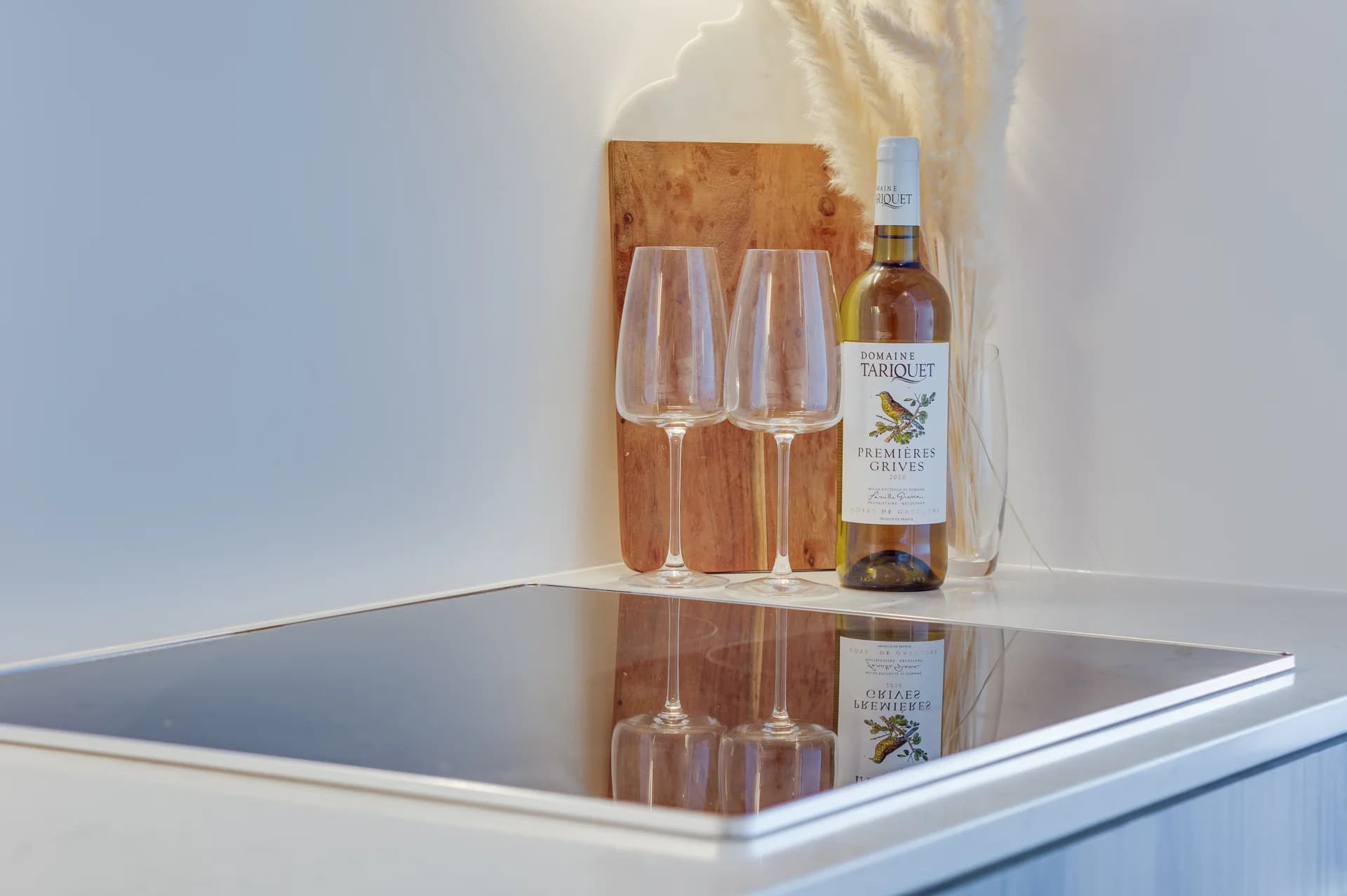 Détail d'un comptoir de cuisine avec plaque de cuisson et verres