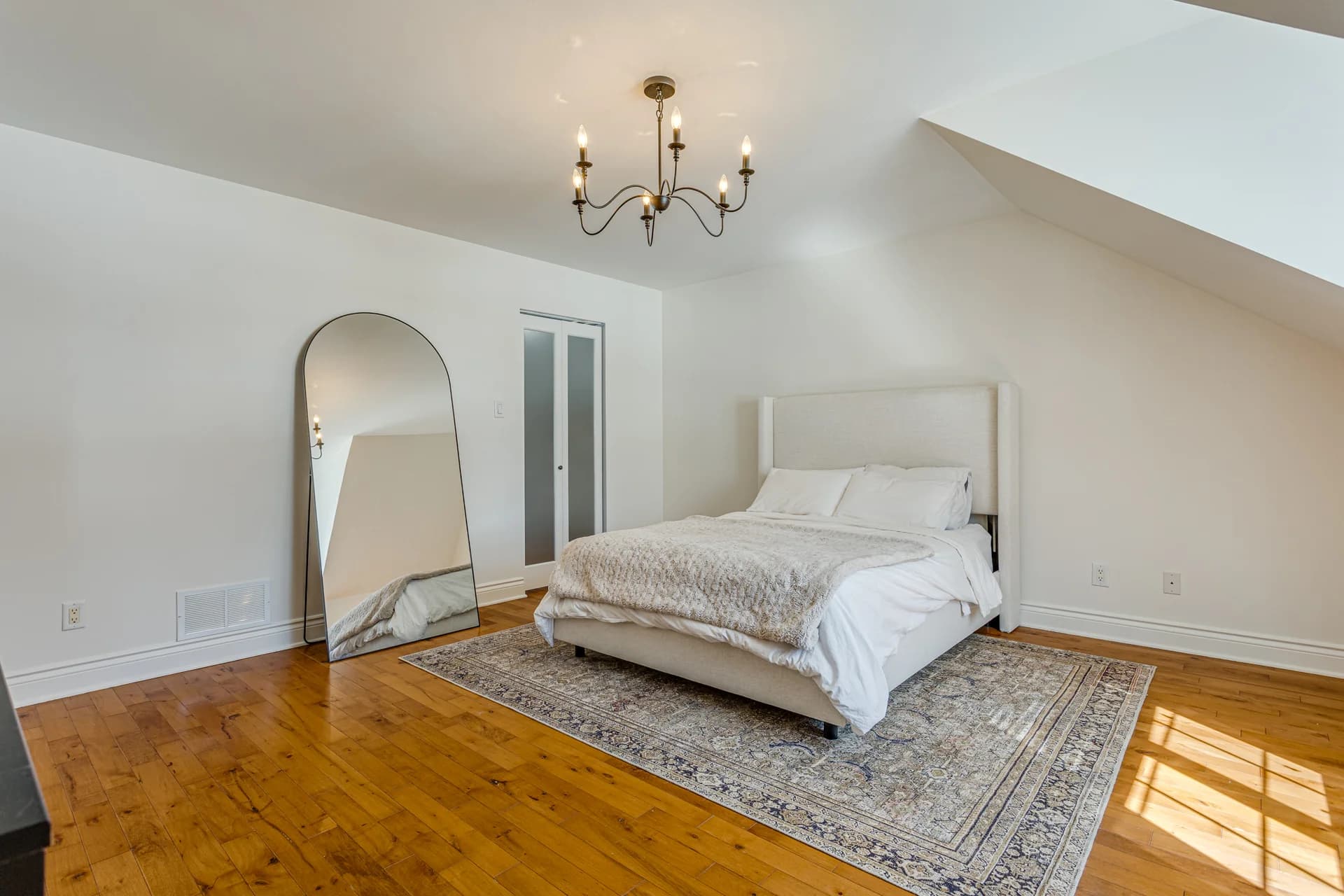 Chambre sous plafond incliné avec plancher de bois