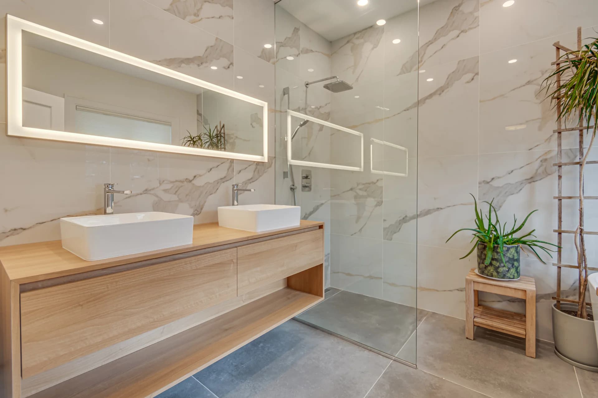 Salle de bain avec double vasque, vanité en bois et douche vitrée