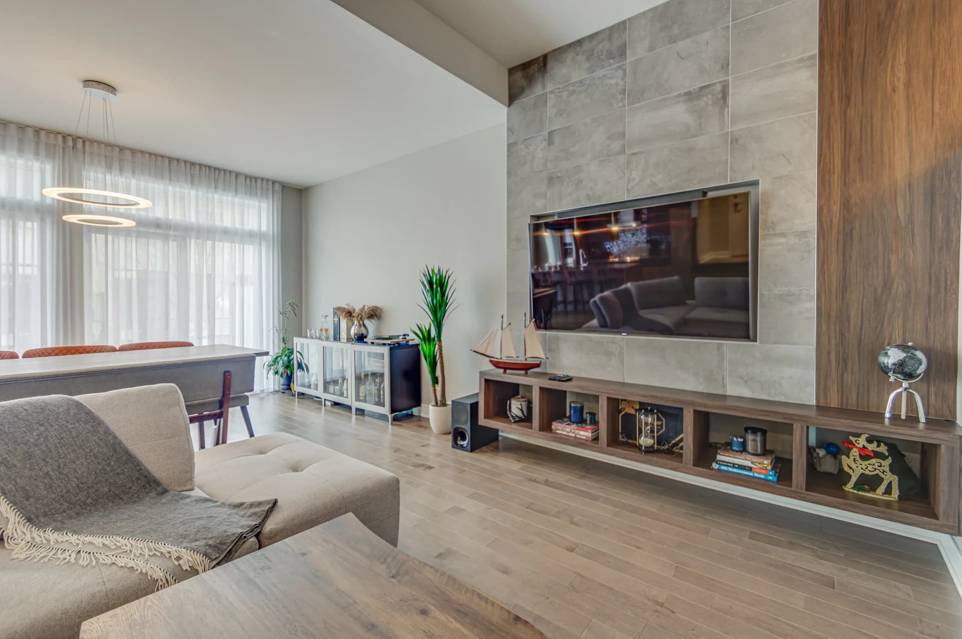 Salon avec mur de télévision en béton et mobilier en bois