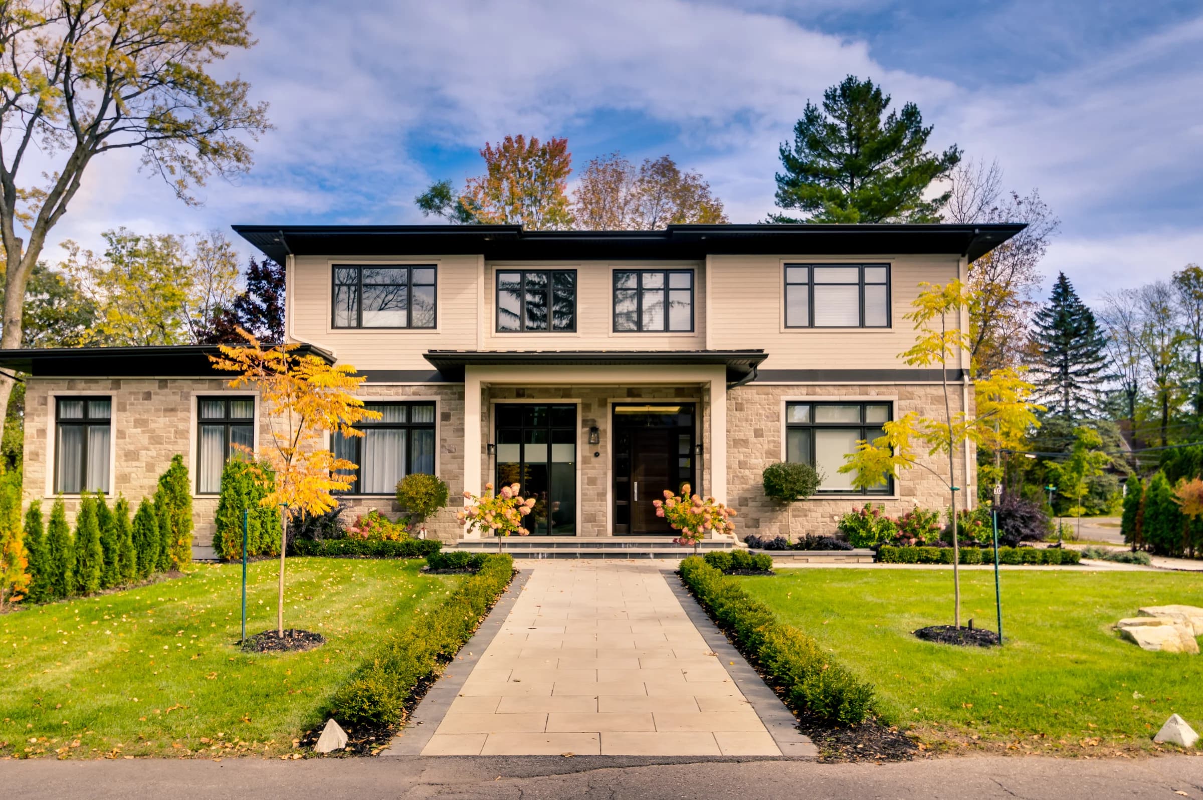 Façade d’une maison contemporaine avec allée centrale et jardin