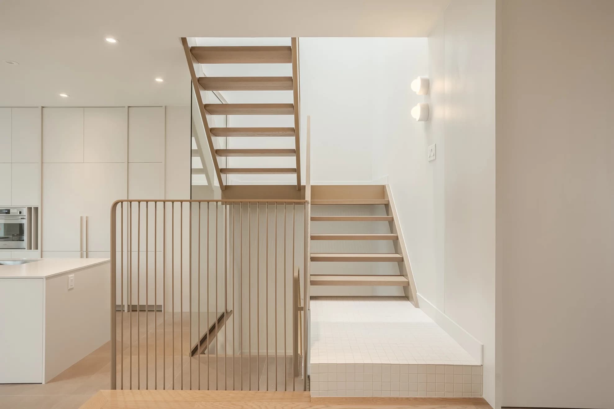 Escalier ouvert en bois dans un intérieur contemporain blanc