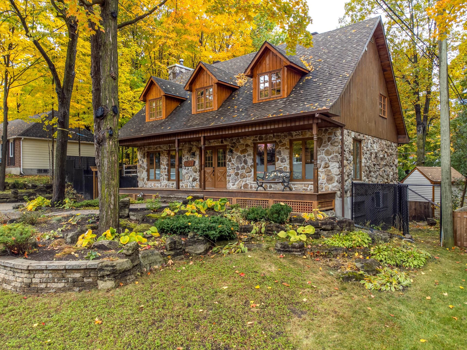 Maison en bois et pierre entourée de feuillage d'automne