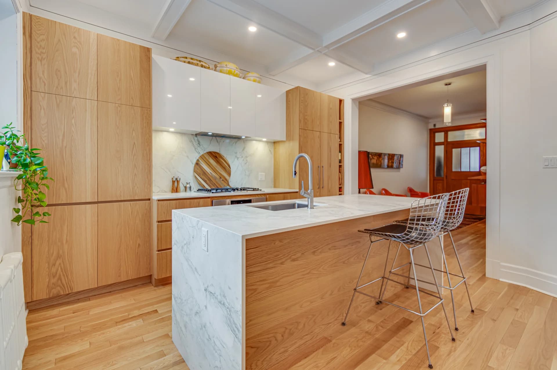 Cuisine en bois avec îlot en pierre veinée et plafond à caissons