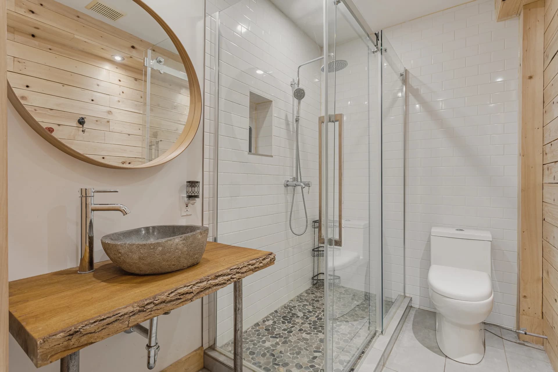 Salle de bain avec vasque de pierre et douche vitrée