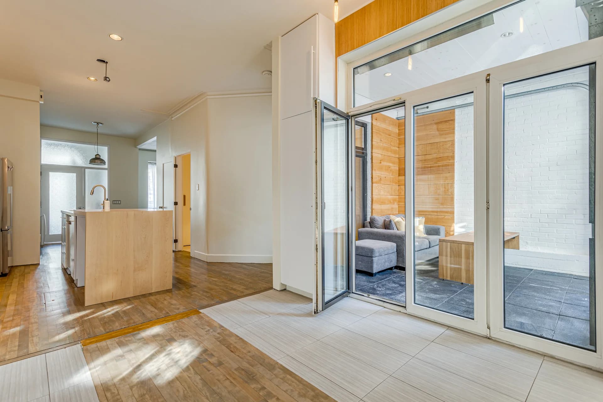 Intérieur lumineux avec grandes portes vitrées vers une terrasse