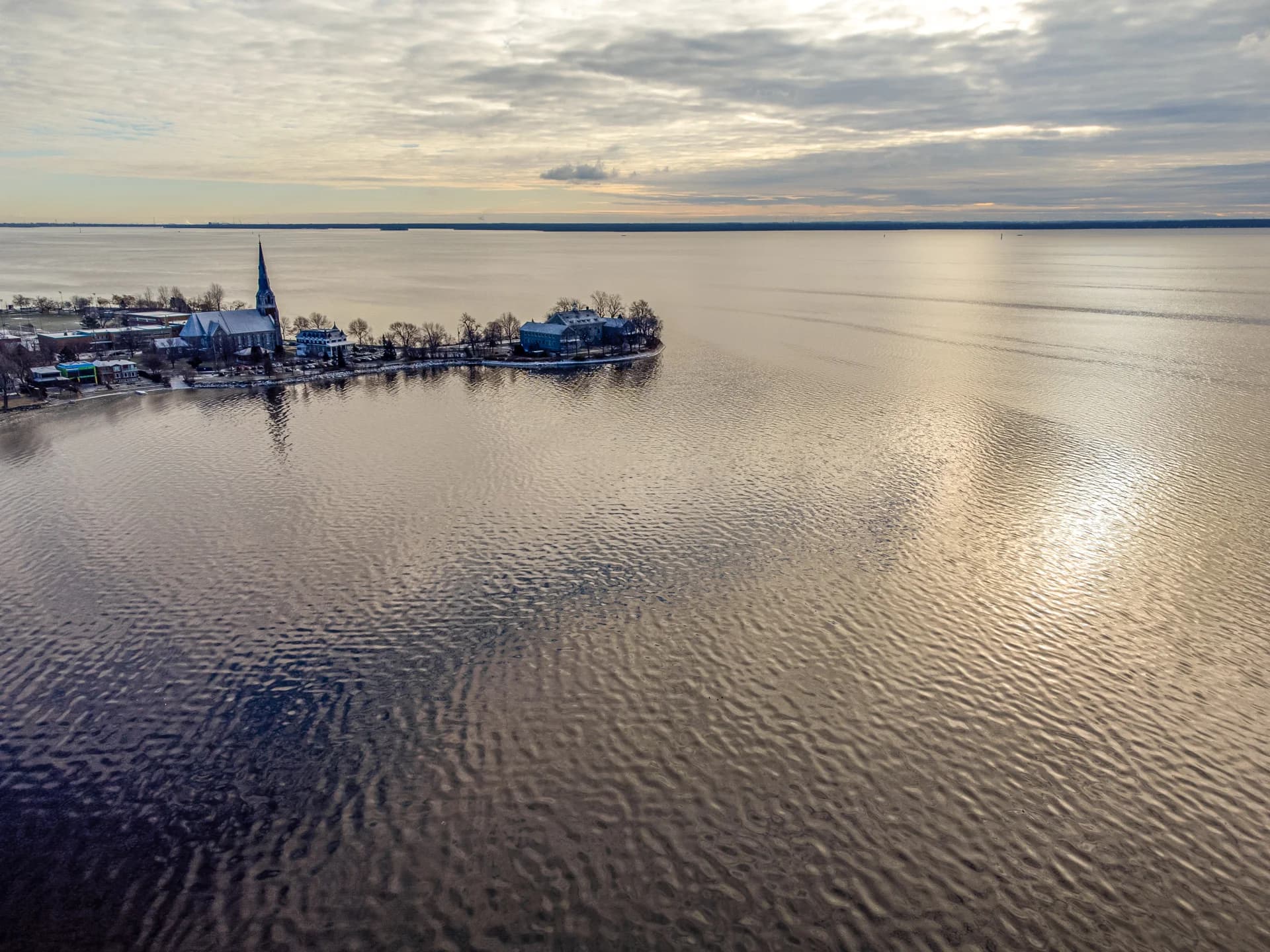 Drone view of a waterfront and church in low sunlight